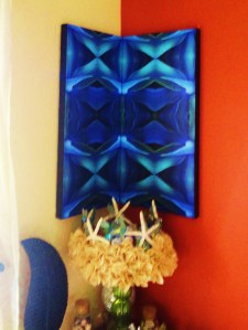 TWO PANELS OF THE SAME IMAGE HUNG IN THE CORNERS.